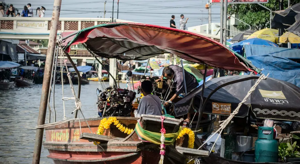 Several small boats in a small stream in Thailand