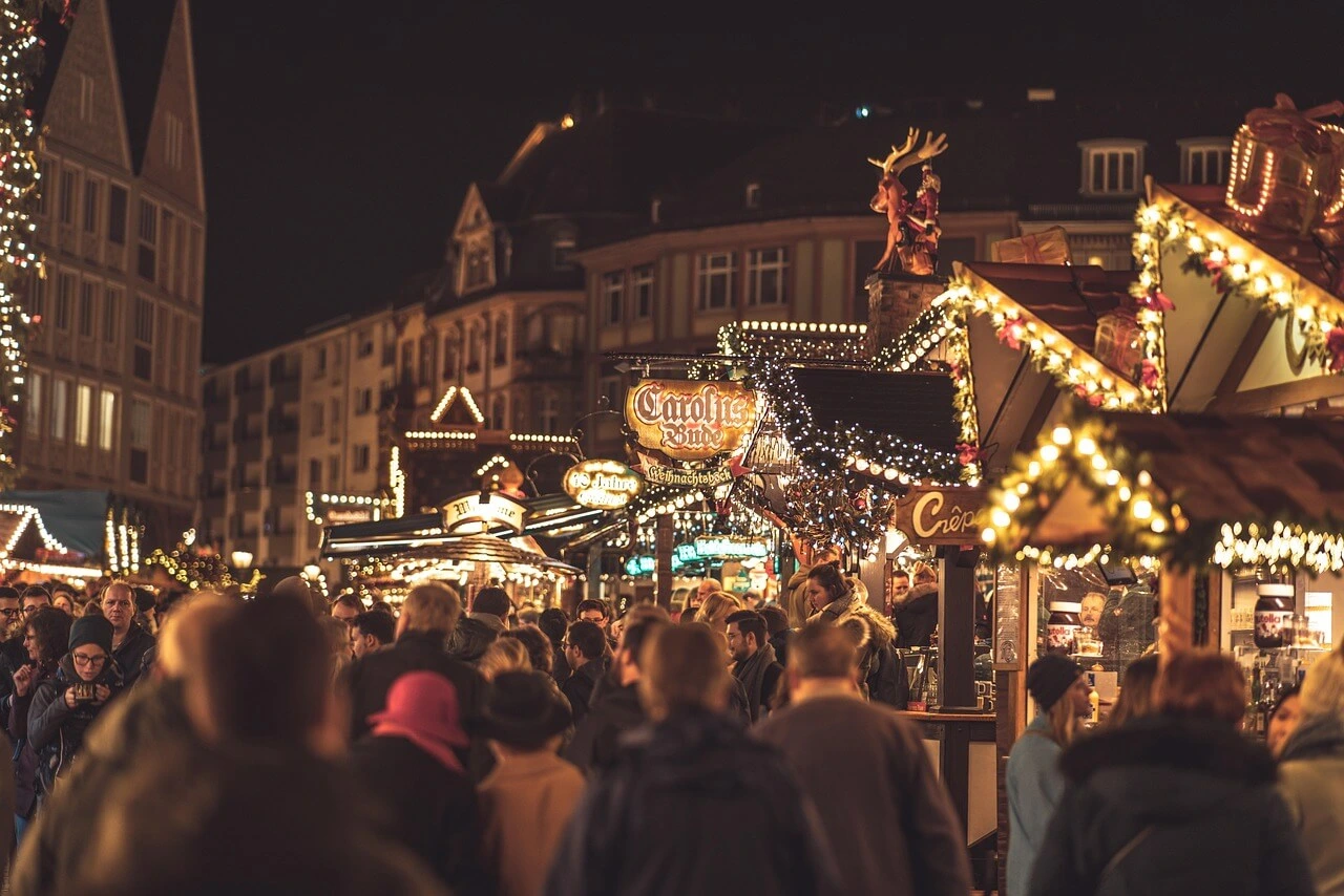 Christmas market huts with crowds in front enjoying the Christmas time