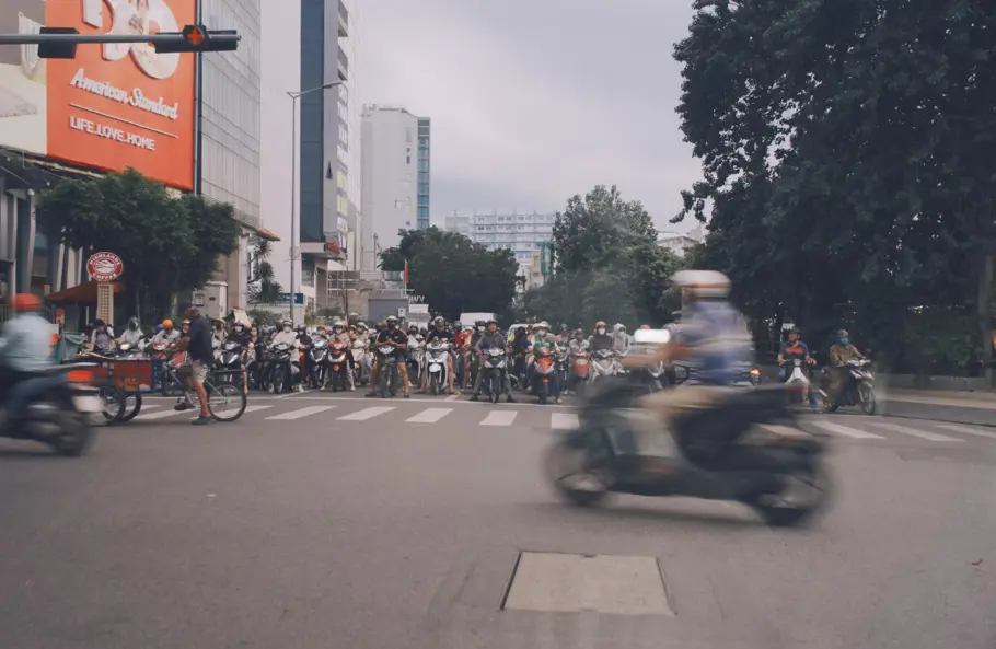 rows of motorcycles waiting at a road crossing in Vietnam