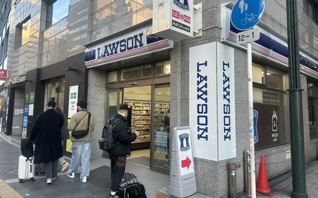 Storefront of a Lawson convenience store in Japan with people in front