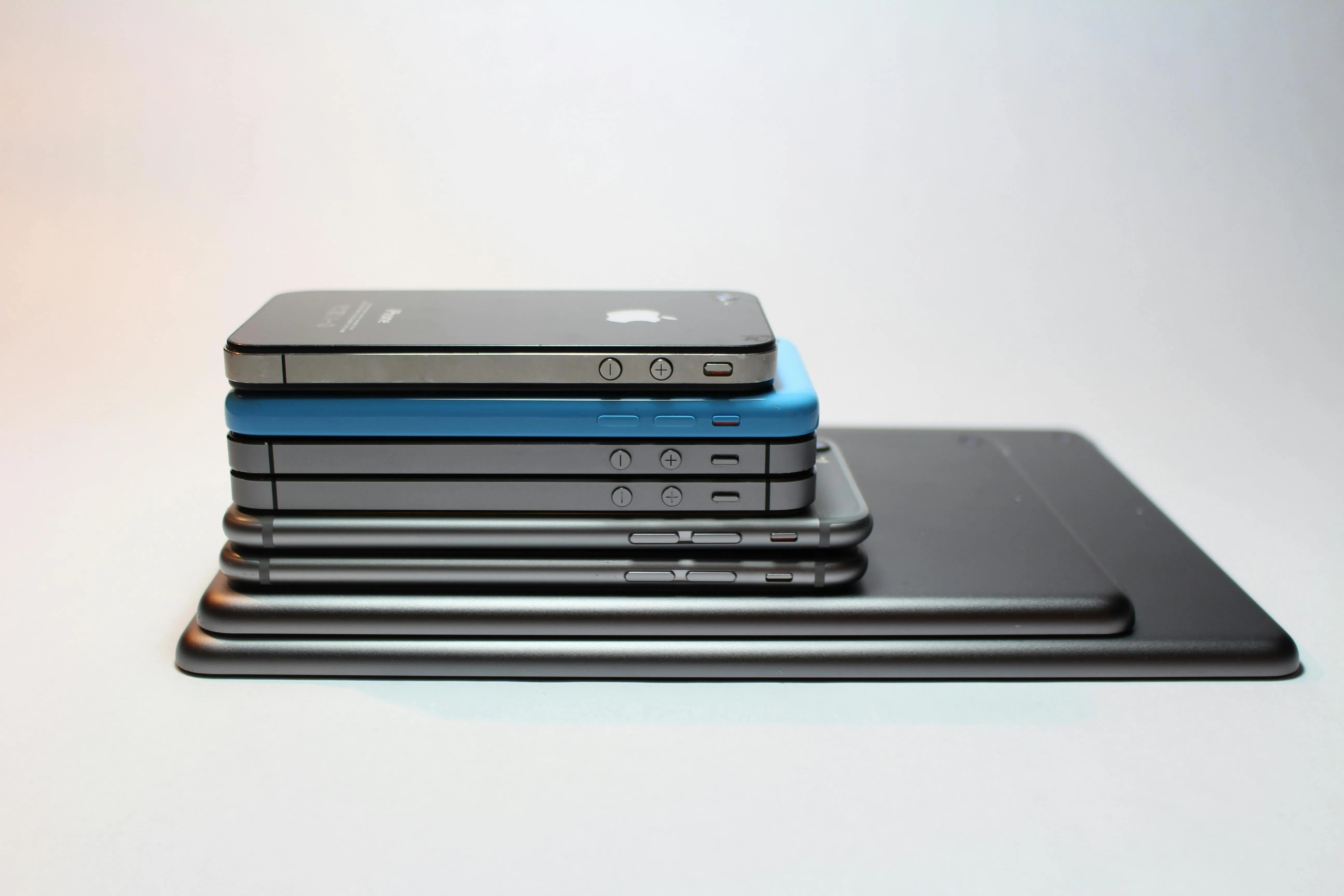 many tablets and iPhones stacked on top of each other