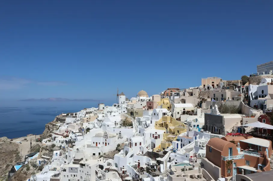 Aerial view of Santorini with blue skies and blue water in the background