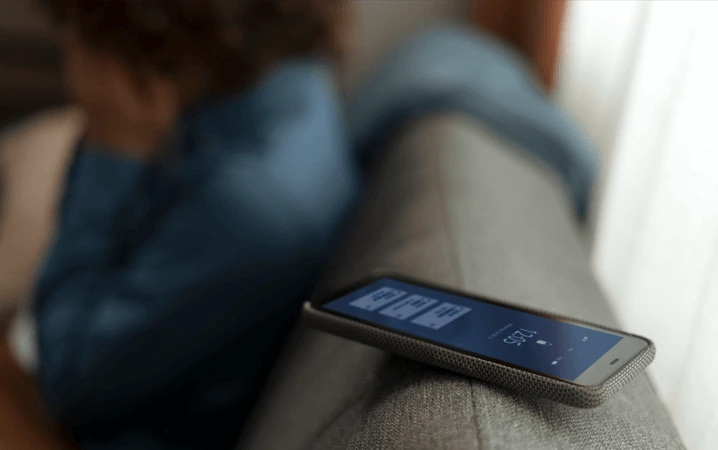phone with sim card laying on the back of the couch