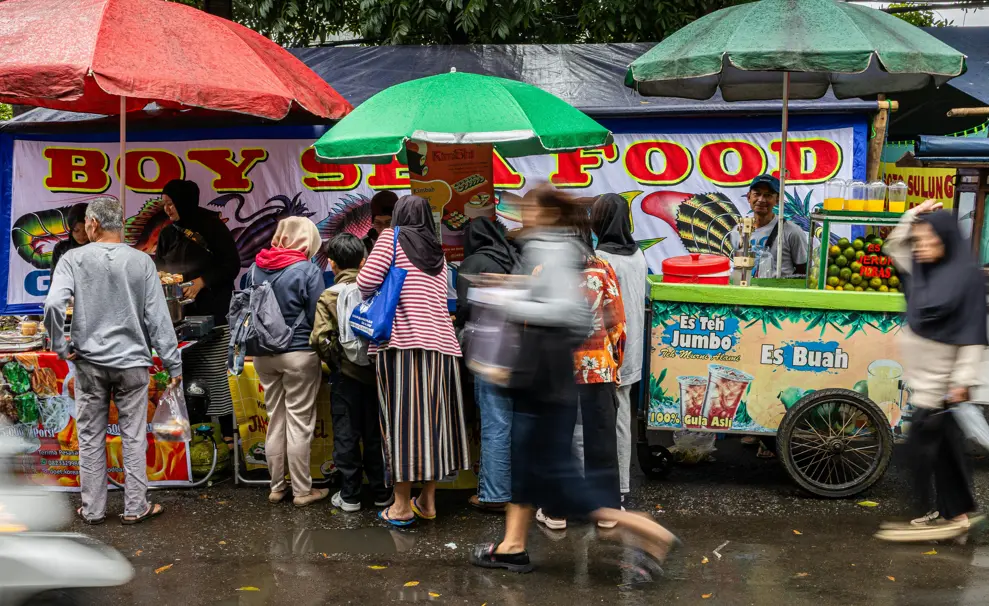 Indonesian street food stalls with people in front of it