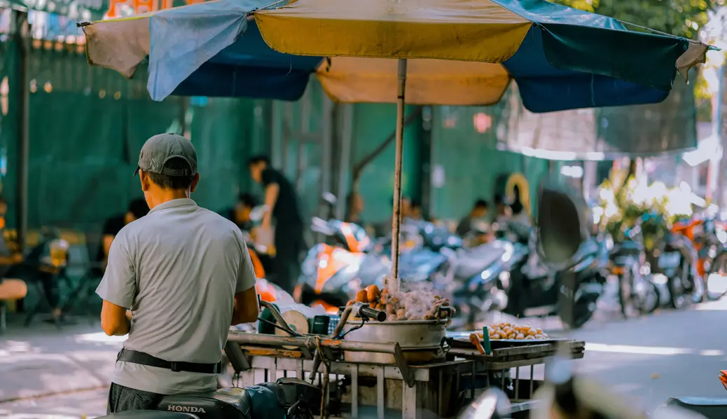 owner sitting next to his street food stall in Vietnam