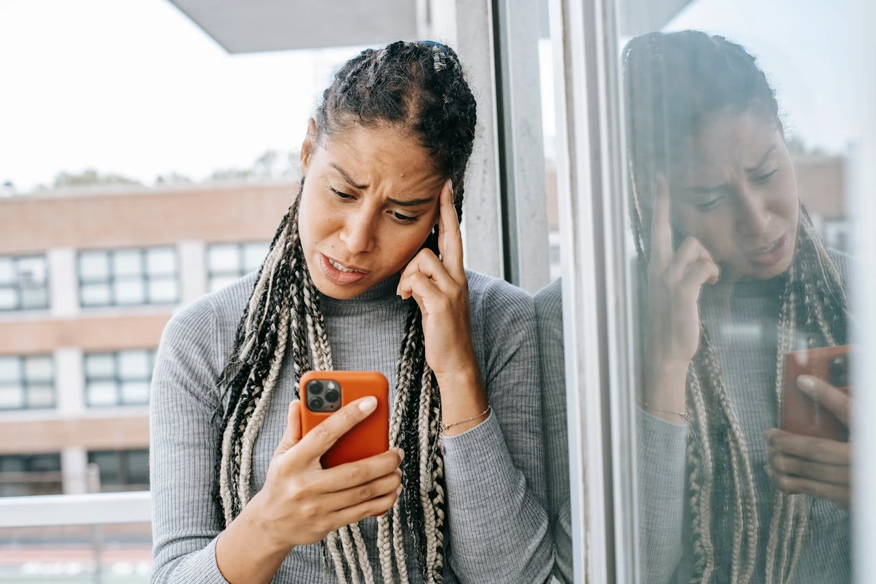 woman looking frustrated while trying to troubleshoot her eSIM transfer on her iPhone